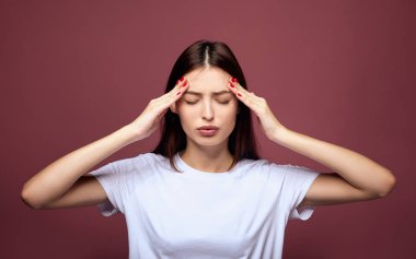 Ciddi, güzel genç bir bayan tapınak tutuyor..