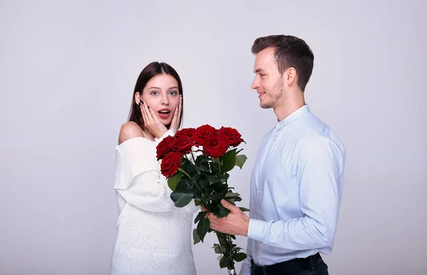 Sorpresa para la dama. Un par de amantes con un ramo de rosas rojas . — Foto de Stock