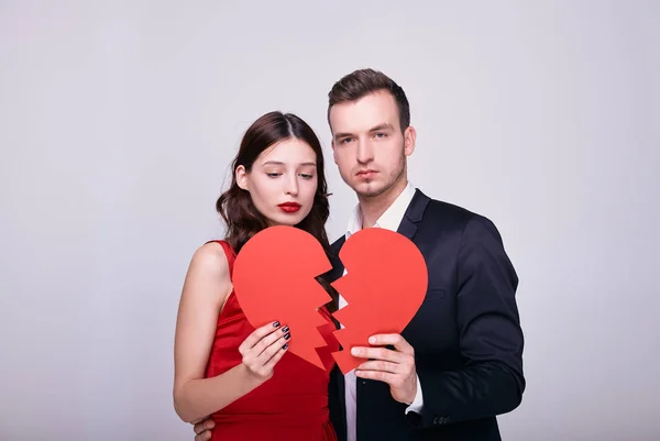 A broken heart in the hands of a beautiful young sad couple. — Stock Photo, Image