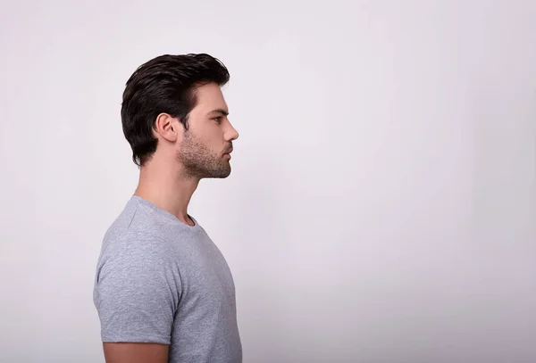 A sporty guy in a gray T-shirt in profile. — Stock Photo, Image