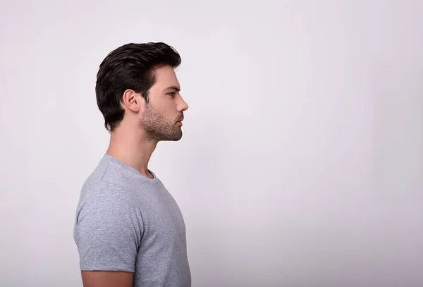 Un tipo deportivo con una camiseta gris de perfil . — Foto de Stock