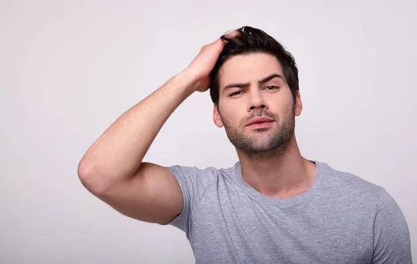 A male model poses on a light background.