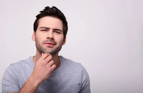 Um belo jovem modelo masculino toca sua barba . — Fotografia de Stock