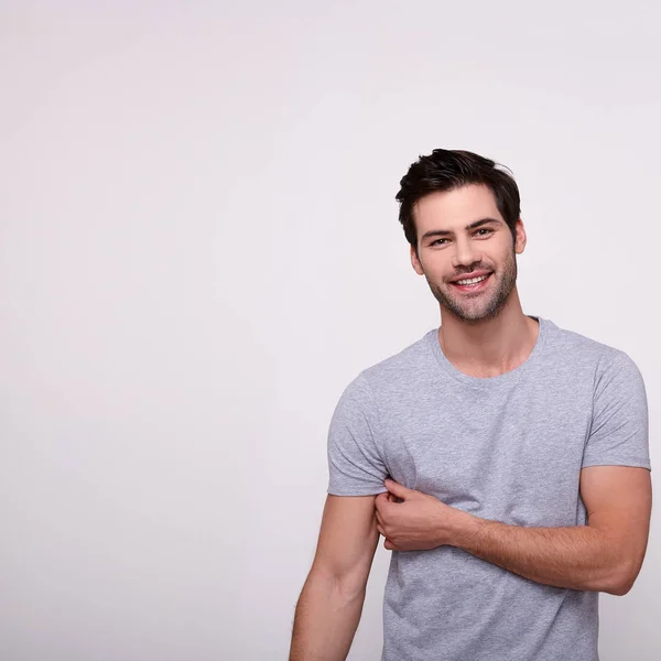 Sorrindo esportes felizes cara jovem em uma camiseta cinza . — Fotografia de Stock