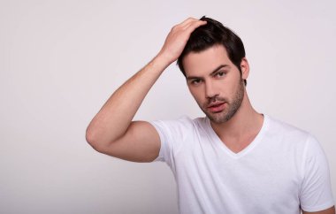 Seksi erkek kameraya bakar ve güzel saçlarına dokunur..