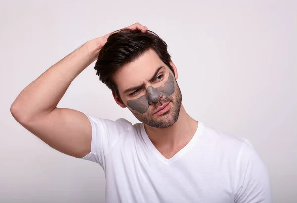 Mladý a pohledný muž s čistící maskou na tváři. — Stock fotografie