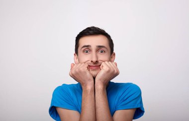 Mavi tişörtlü, korkmuş bir genç..