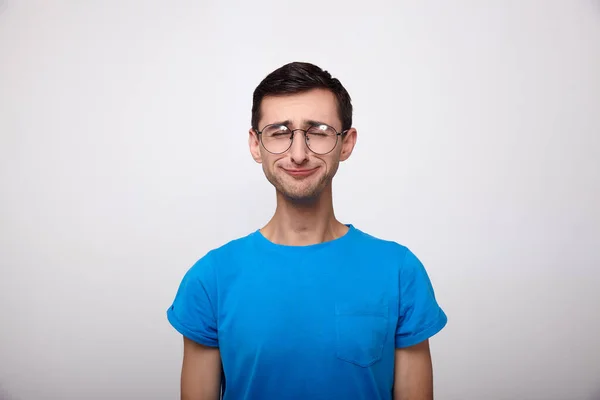 Sad young white boy in a blue T-shirt and glasses. — Stock Photo, Image