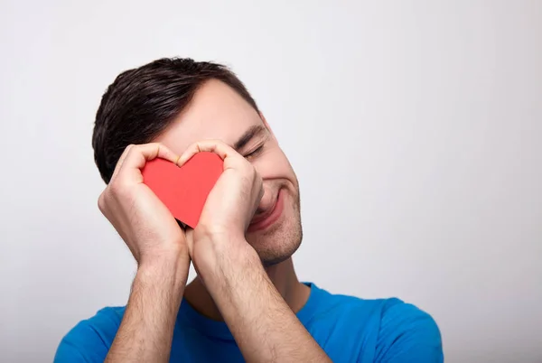 A cute white young man with a red heart in his hands. — 스톡 사진