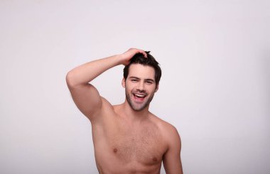 Mutlu vahşi yakışıklı adam saçlarına dokunuyor.