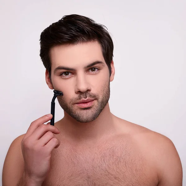Soustředěný brutální samec s břitvou u vousů — Stock fotografie