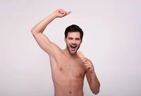 Guapo joven feliz peinándose el pelo . —  Fotos de Stock