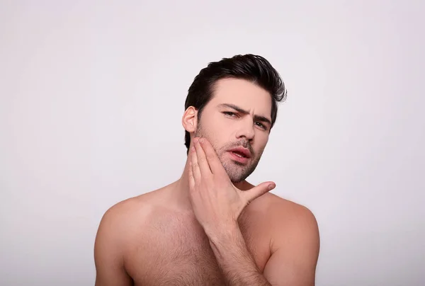 El hombre sin afeitar toca su barba —  Fotos de Stock