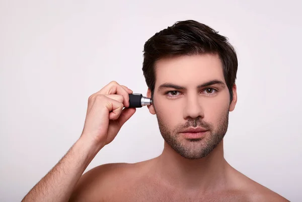 Κοντινό πλάνο, ένας όμορφος άντρας αφαιρεί τα μαλλιά στην τεχνολογία του με ένα ψαλίδι.. — Φωτογραφία Αρχείου