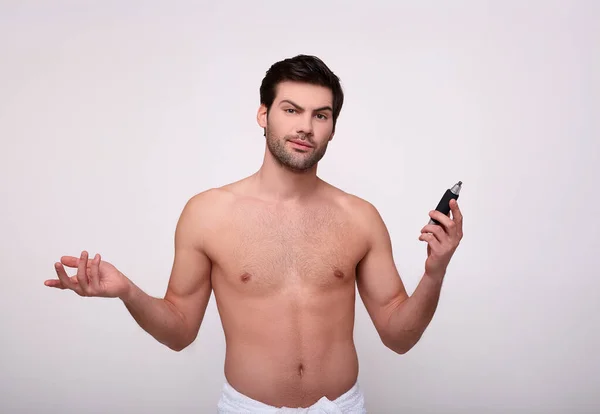 Chico sorprendido después de la ducha con un trimmer en la mano . — Foto de Stock