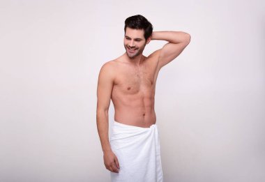 Arka planda beyaz havluyla gülümseyen acımasız adam.