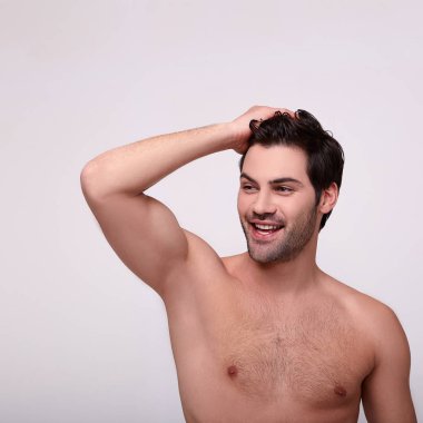 Güzel gövdeli bir adam yana bakıyor.