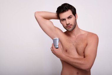 Beyaz arka planda deodorantı olan seksi maço..
