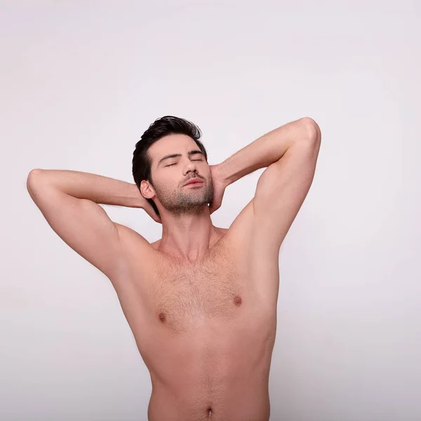Komea seksikäs mies poseeraa eristetty harmaa . — kuvapankkivalokuva