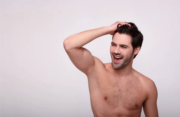 Entusiasta chico mira hacia otro lado y sostiene su mano en su cabello —  Fotos de Stock