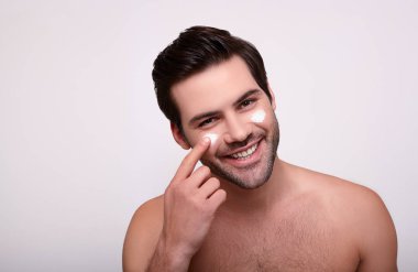 Gülen tatlı esmer, yüzünde kremayla.