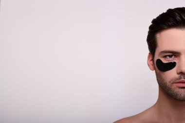 Yama takmış, ciddi bir genç adamın resmi..