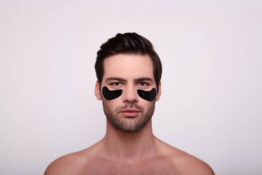 Gözlerinin altında siyah lekeler olan çekingen esmer..