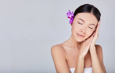 Saçında çiçek olan güzel bir kız gözlerini kapadı..