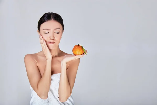 Surprised young Asian woman with an orange in the arm. — ストック写真