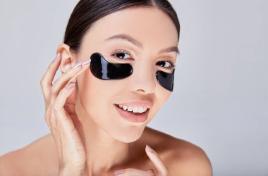 Close-up, the face of a young smiling Asian woman with perfect skin and patches.