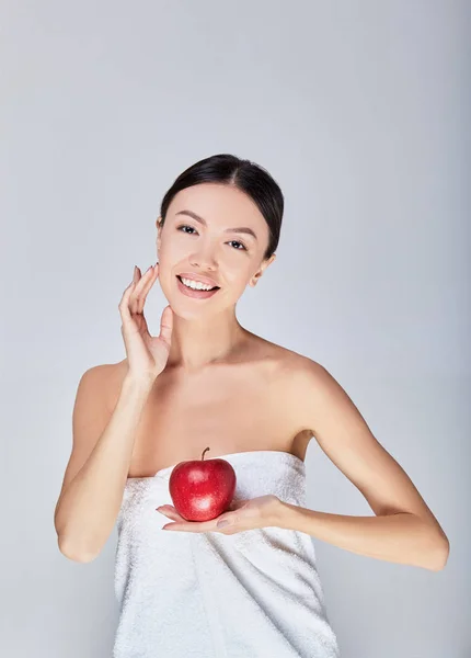 Симпатичная девушка позирует с красным яблоком в руке . — стоковое фото