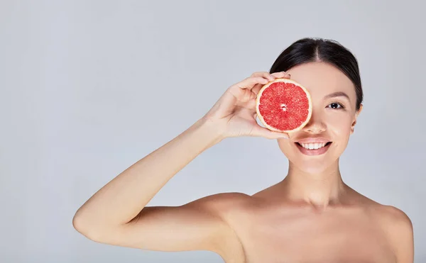 An image of a cute fun young model with citrus on her face. — 스톡 사진