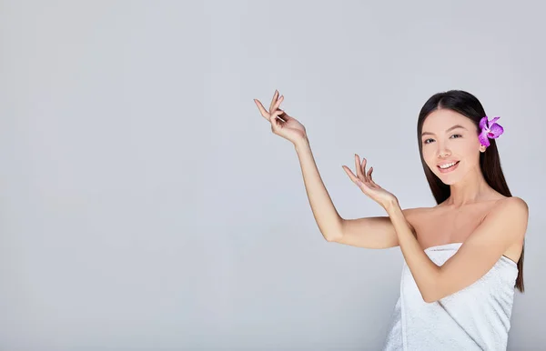 Encantadora mujer asiática con una sonrisa y flores en el pelo . — Foto de Stock