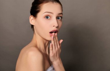 Elbiseleri olmayan, şaşırmış, kahverengi saçlı güzel bir kadının görüntüsü..