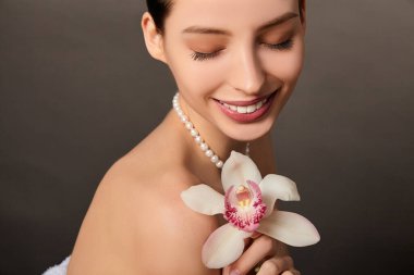Beyaz orkide çiçeğiyle romantik bir genç kız.
