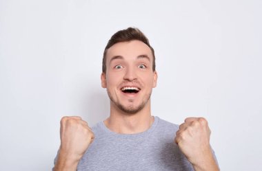 Genç yakışıklı bir adam zaferle, şansla sevinir..