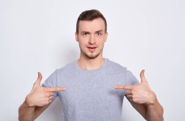 Genç beyaz bir adam kendini işaret ediyor..