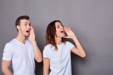 Sevimli, neşeli çift, gri bir arka plana karşı çığlık atıyor..