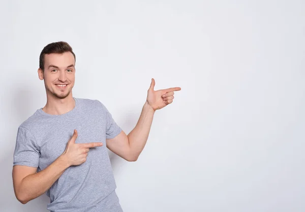 Um homem bonito aponta os dedos para a direita. . — Fotografia de Stock