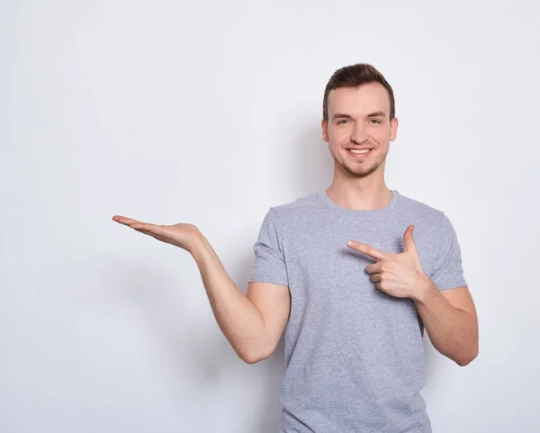 El joven señala con el dedo hacia un lado . — Foto de Stock