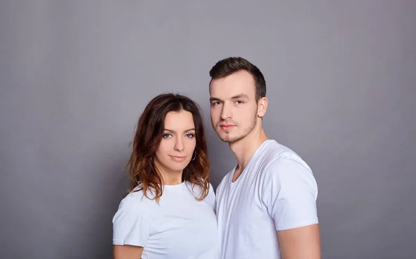 Um belo jovem casal em camisetas brancas . — Fotografia de Stock