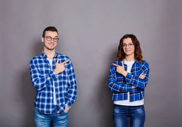 Смішна молода пара в блакитних сорочках на сірому фоні . — стокове фото