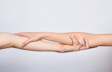 İki genç beyaz el birbirine dokunuyor, birbirlerine sarılıyorlar, beyaz bir arka plana dökülüyorlar. Aşk kavramı, sonsuza dek birlikte, destek.