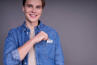 Neşeli Kafkasyalı adam cebine bir prezervatif koyar ve bir kadınla geçireceği unutulmaz gecenin tadını çıkarır. Pozitif stil sahibi bir adam sağlıklı bir yaşam tarzını ve ilişkileri teşvik eder..