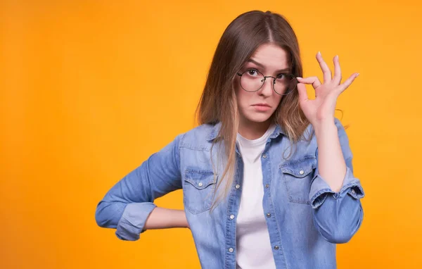 Überraschter Stilvoller Teenager Jeansjacke Hält Die Rechte Hand Brillenrand Okay — Stockfoto