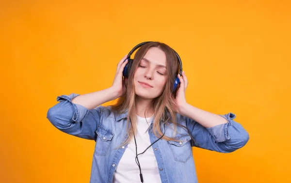 Portret Dziewczyny Luźnych Ciuchach Która Chętnie Słucha Muzyki Słuchawkach Żółtym — Zdjęcie stockowe
