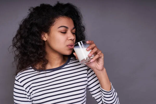 줄무늬 스웨터를 곱슬곱슬 우유를 마시고 음료를 즐기고 배경에 포즈를 아프리카계 — 스톡 사진