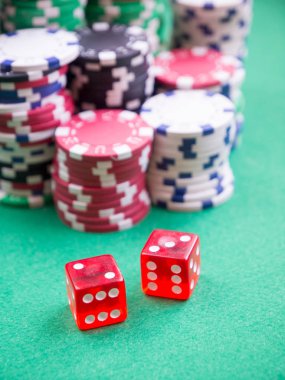 Yeşil masada küp ve poker fişleri