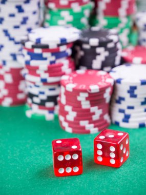 Yeşil masada küp ve poker fişleri