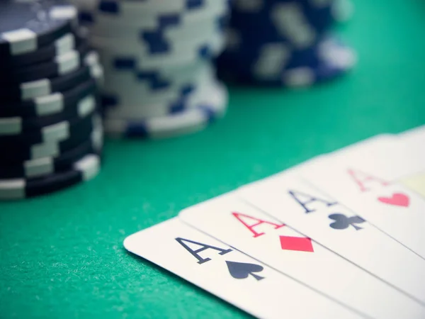 Yeşil masada poker fişleri olan dört as.